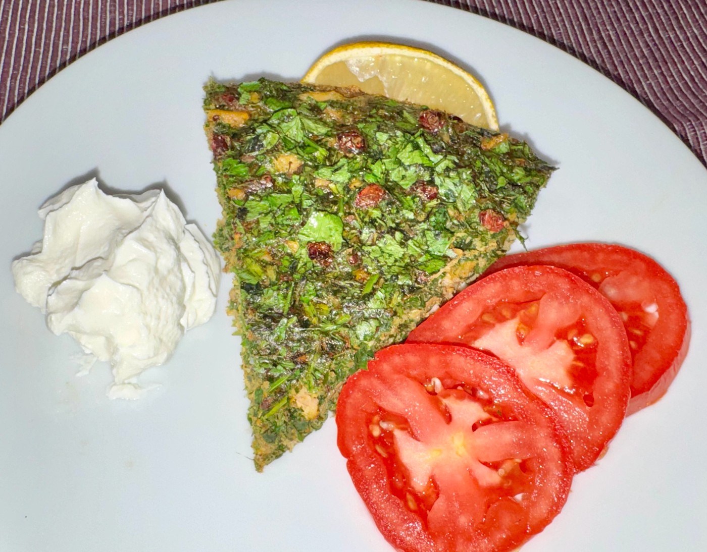 Original photograph of Robert’s herb-rich kuku sabzi with tomatoes and a creamy accompaniment